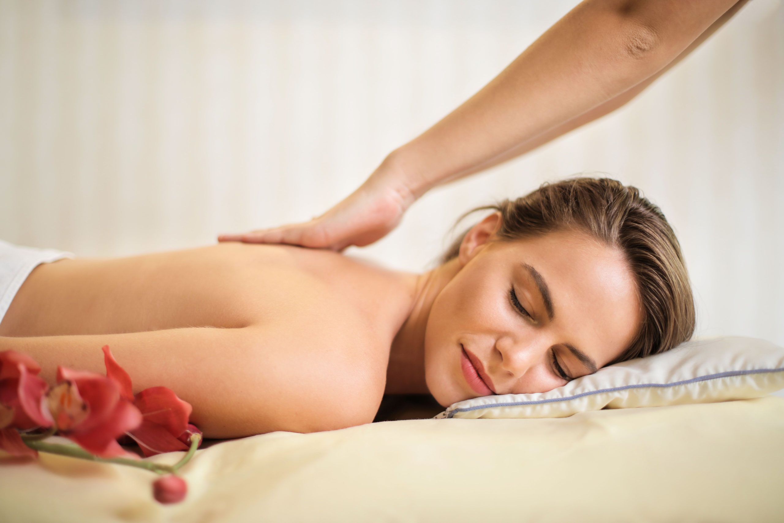 Massage op locatie A serene spa scene featuring a woman receiving a therapeutic massage, surrounded by soothing elements.